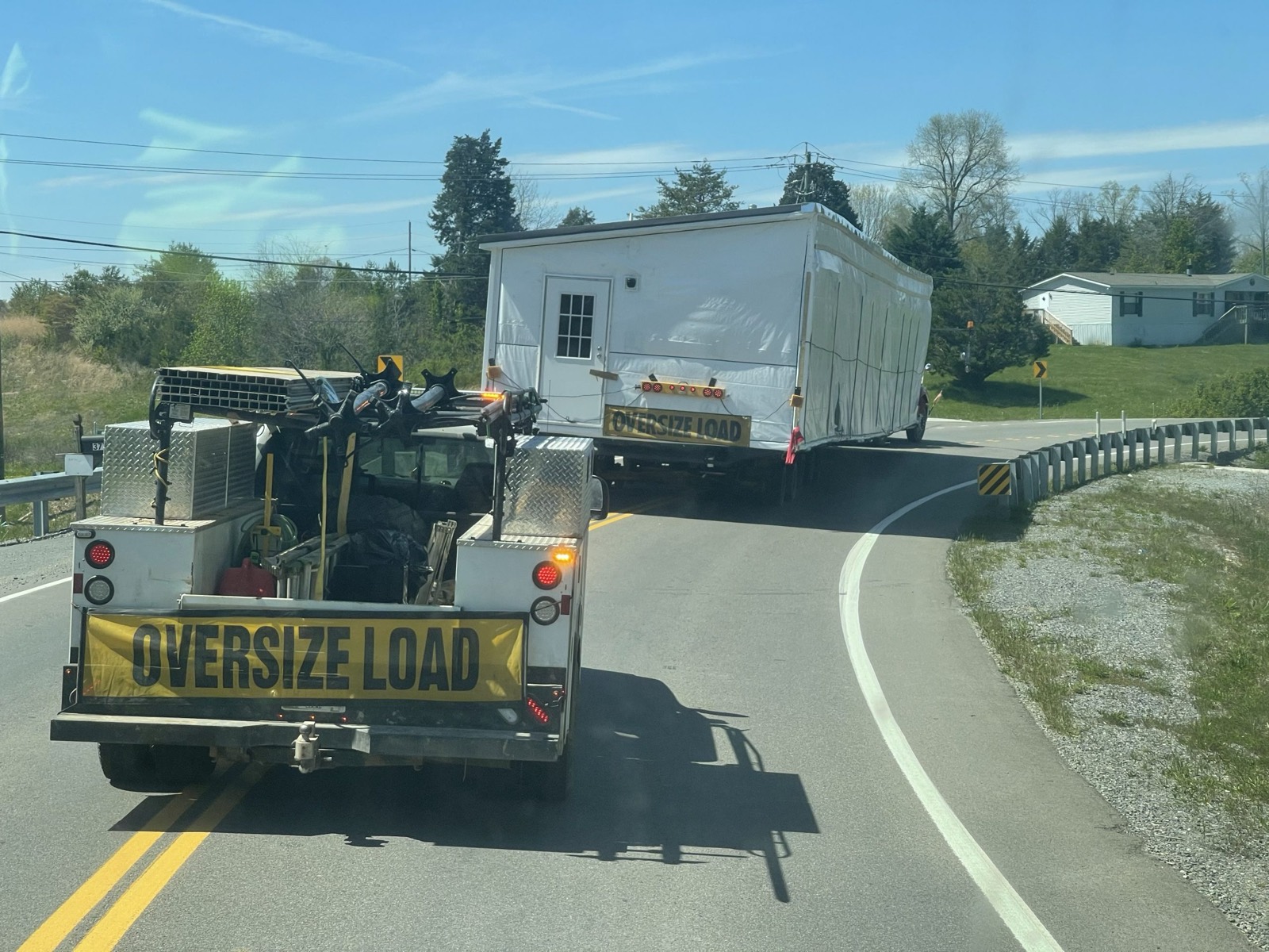 Oversize-load toter hauling a double-wide on the highway